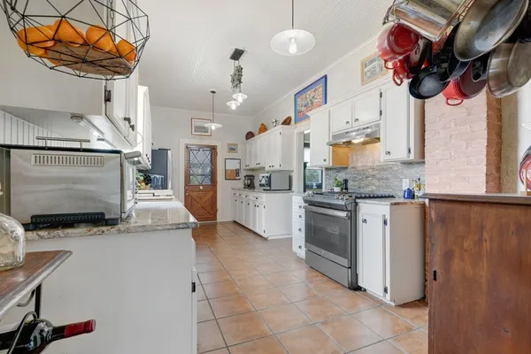 a kitchen with stainless steel appliances granite countertop a refrigerator and a stove top oven