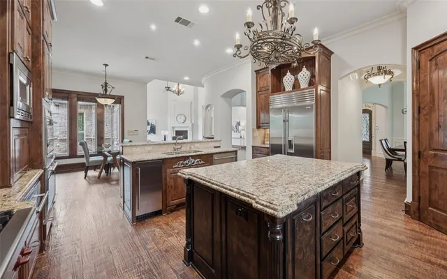 a kitchen with a counter top space a sink appliances and cabinets