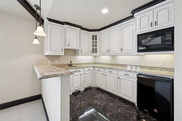 a kitchen with granite countertop white cabinets stainless steel appliances and a sink