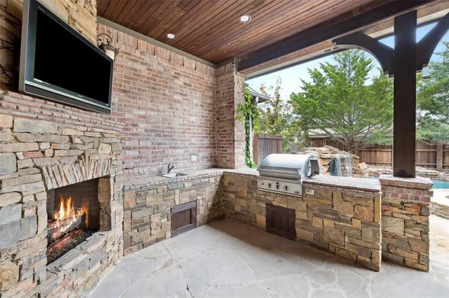 a living room with stainless steel appliances furniture a fireplace and a flat screen tv