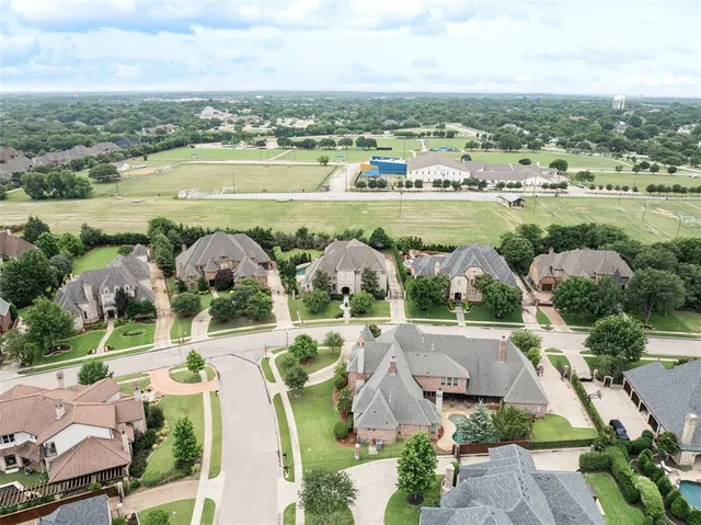 an aerial view of a city with lots of residential buildings ocean and mountain view in back