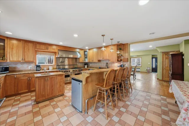 a kitchen with stainless steel appliances kitchen island granite countertop a table chairs and a sink