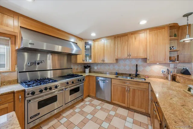 a kitchen with stainless steel appliances granite countertop a stove a sink and a refrigerator