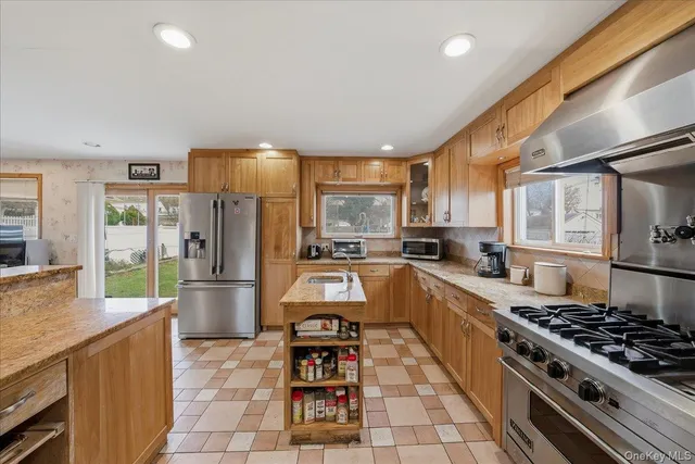 a large kitchen with stainless steel appliances a stove a sink dishwasher and cabinets with wooden floor