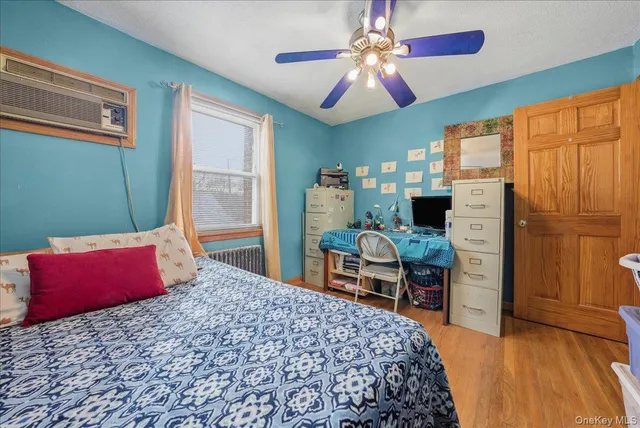 a bedroom with a bed dresser and a large window