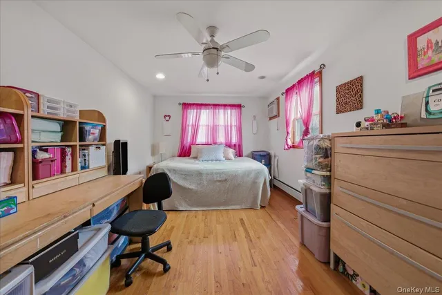 a bedroom with a bed and a bookshelf with wooden floor