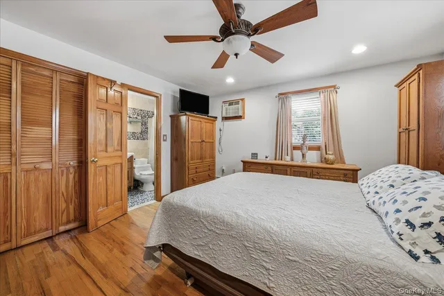 a bedroom with a bed dresser and a large window