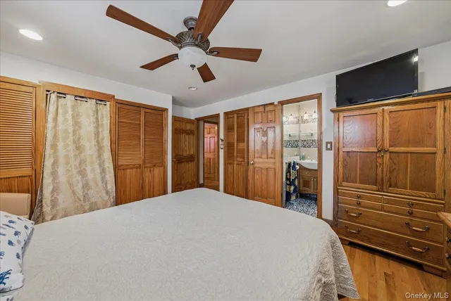 a bedroom with a large bed and a flat tv screen
