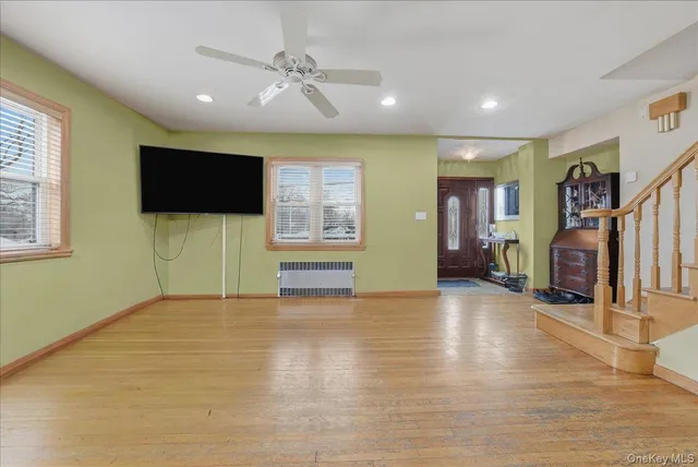 a view of a livingroom with wooden floor and a ceiling fan