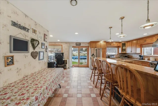 a open kitchen with stainless steel appliances kitchen island granite countertop a refrigerator and microwave