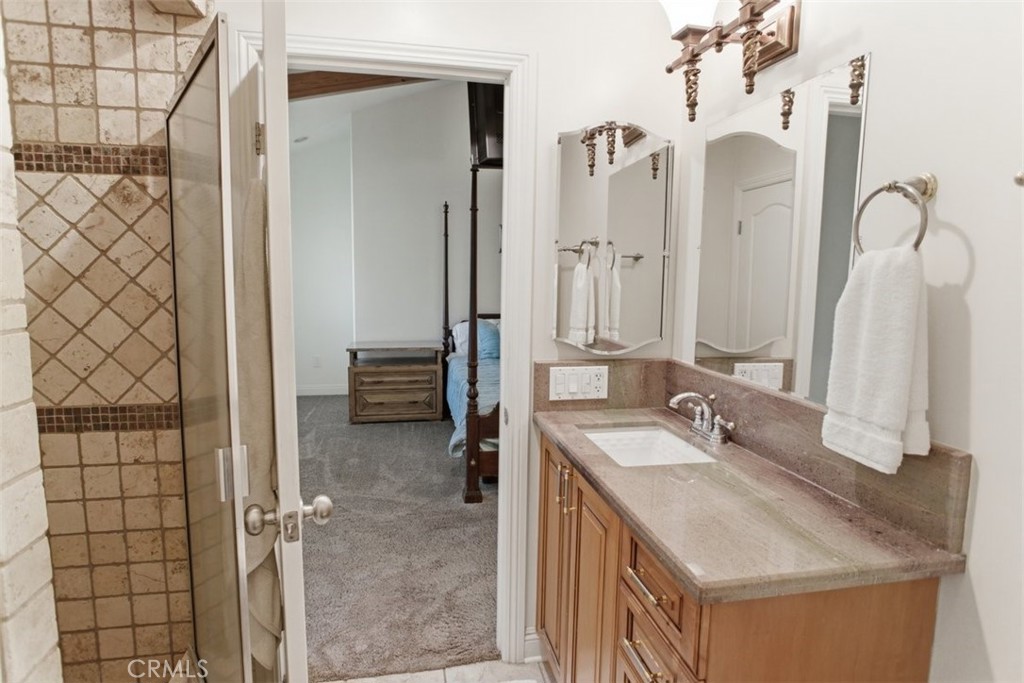 31233 Romero Canyon Road Castaic, CA 91384 - Photo 24 of 38 a en suite bathroom with a granite countertop sink and a mirror