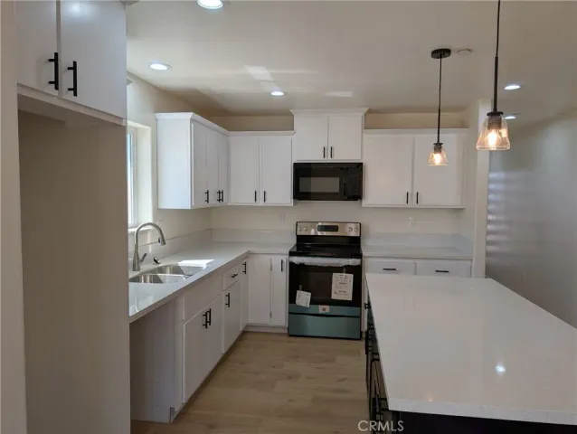 a kitchen with appliances a sink a counter space and cabinets
