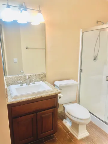 a bathroom with a granite countertop sink toilet and shower