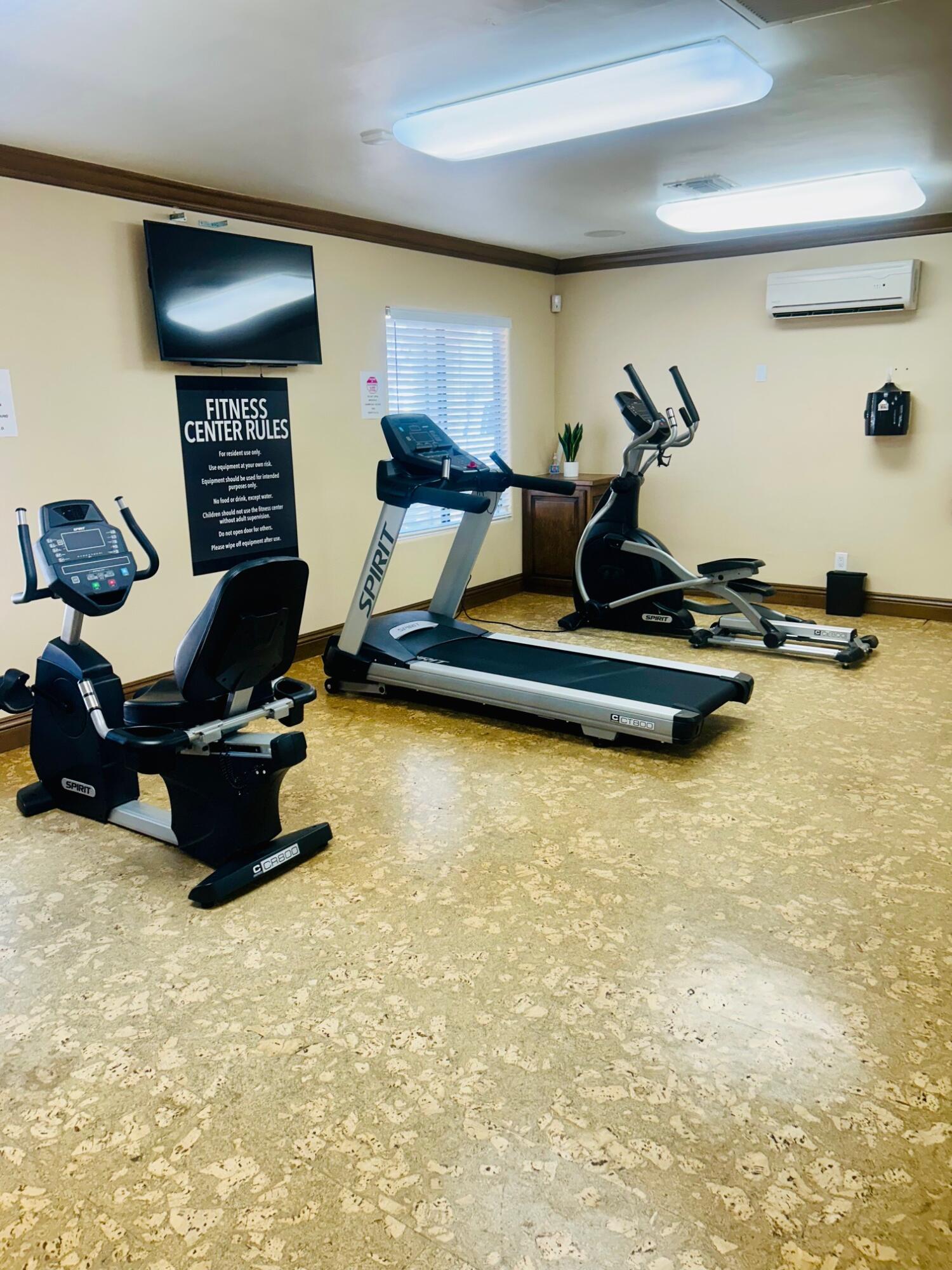 40780 Breezy Pass Road, Unit B Palm Desert, CA 92211 - Photo 30 of 32 a living room with furniture gym equipment and a flat screen tv