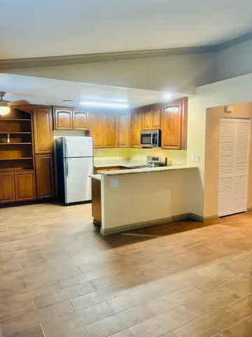 a view of kitchen with furniture and refrigerator
