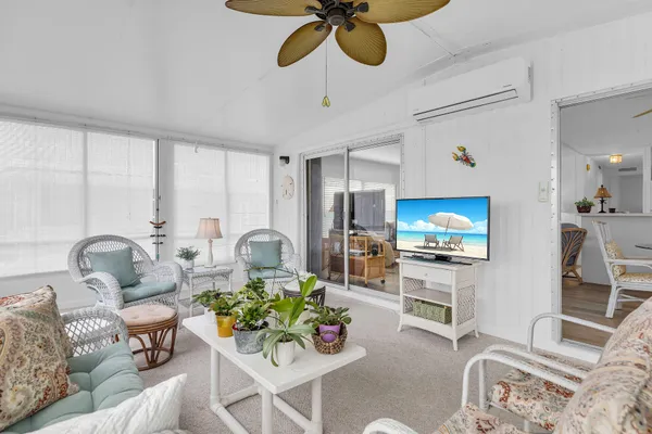 a living room with furniture a dining table and a flat screen tv