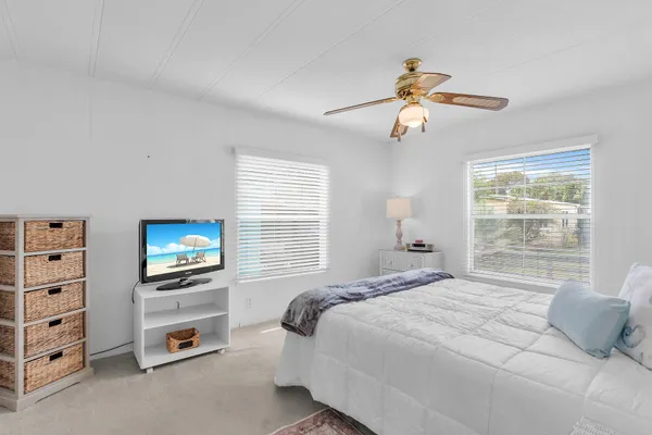 a bedroom with a bed a dresser and a chandelier
