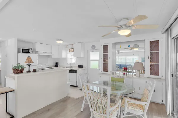a kitchen with white cabinets and chairs