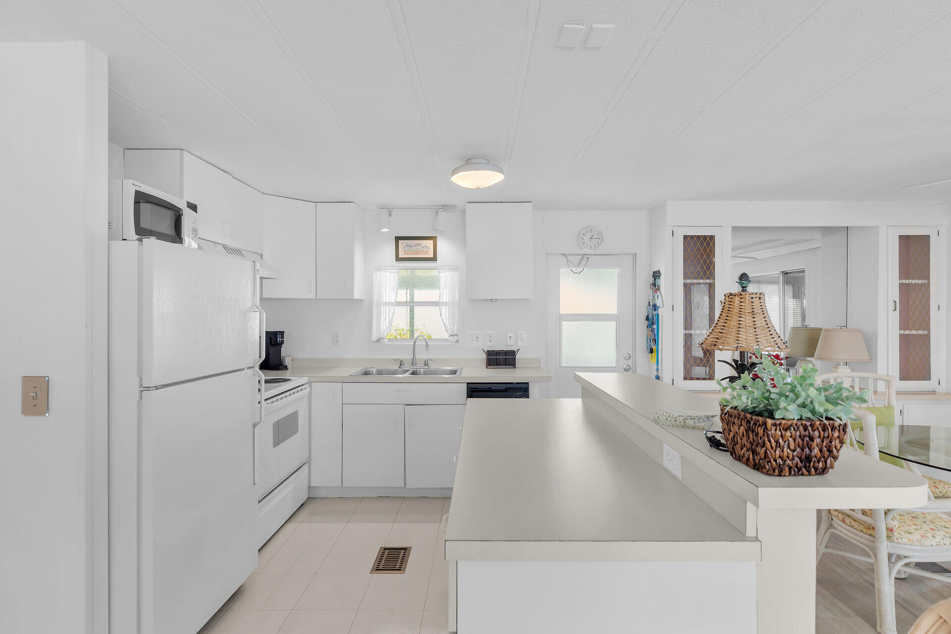 812 South Silver Circle Key Largo, FL 33037 - Photo 7 of 41 a kitchen with granite countertop a refrigerator a sink a stove and white cabinets