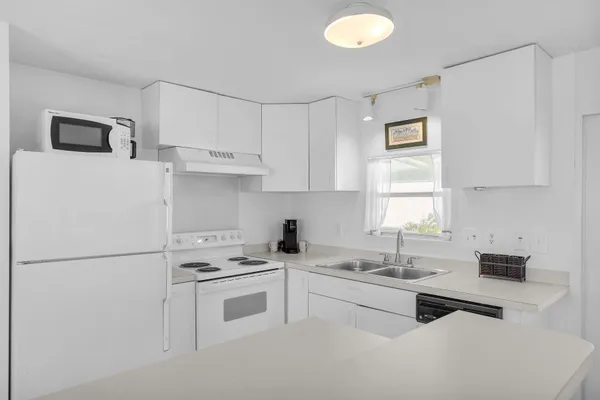 a kitchen with white cabinets and white appliances