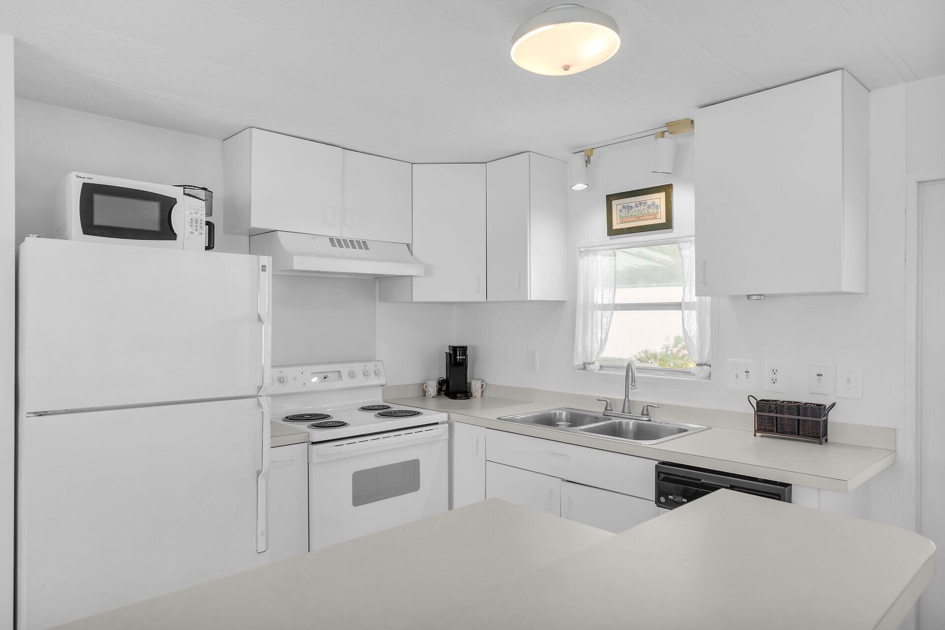 812 South Silver Circle Key Largo, FL 33037 - Photo 8 of 41 a kitchen with white cabinets and white appliances