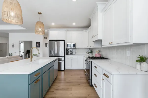 a kitchen with kitchen island granite countertop a sink stainless steel appliances and white cabinets