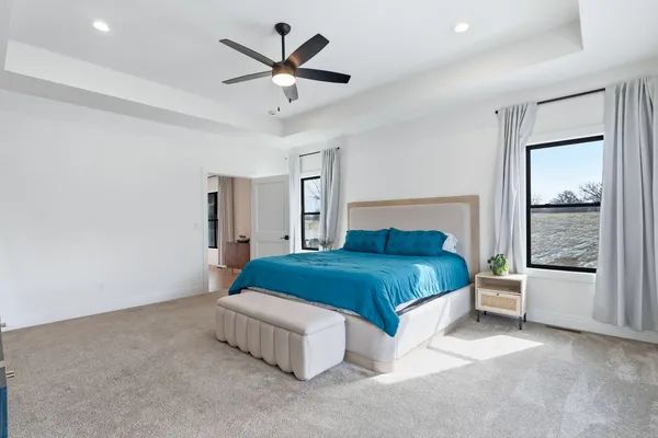 a spacious bedroom with a bed and a ceiling fan