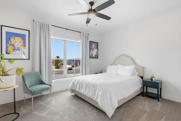 a bedroom with a bed couch and a painting on the wall