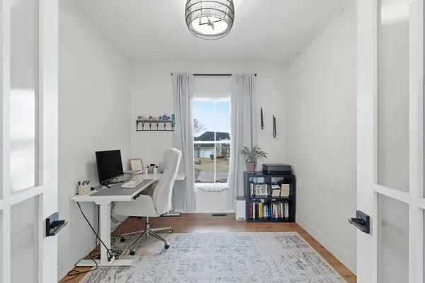 a view of a workspace with furniture and a window