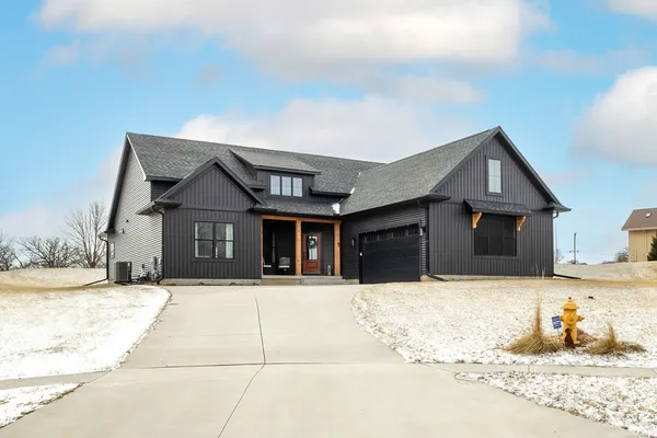 a front view of a house with a yard covered in snow
