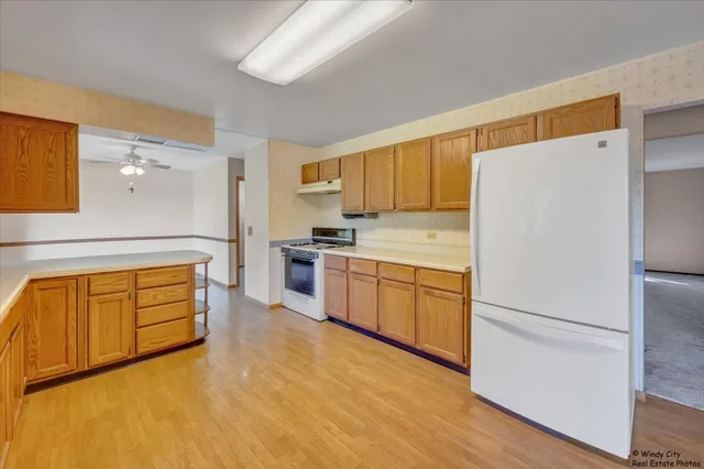 a kitchen with granite countertop appliances a sink and a refrigerator