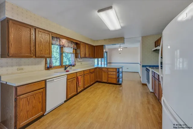 a kitchen with stainless steel appliances granite countertop a sink counter space cabinets and a large window