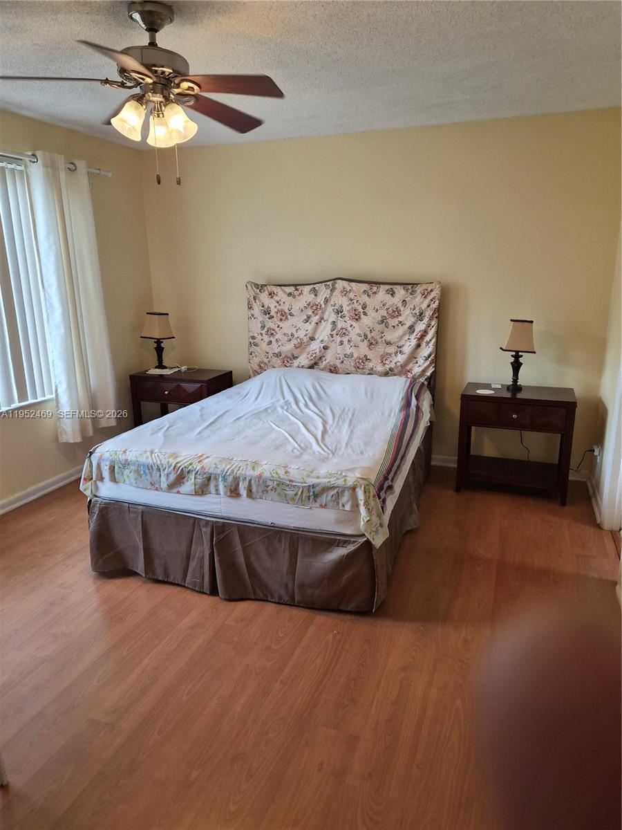 1101 Northwest 58th Terrace, Unit 202 Sunrise, FL 33313 - Photo 4 of 12 a bed sitting in a bedroom next to a window and a chandelier