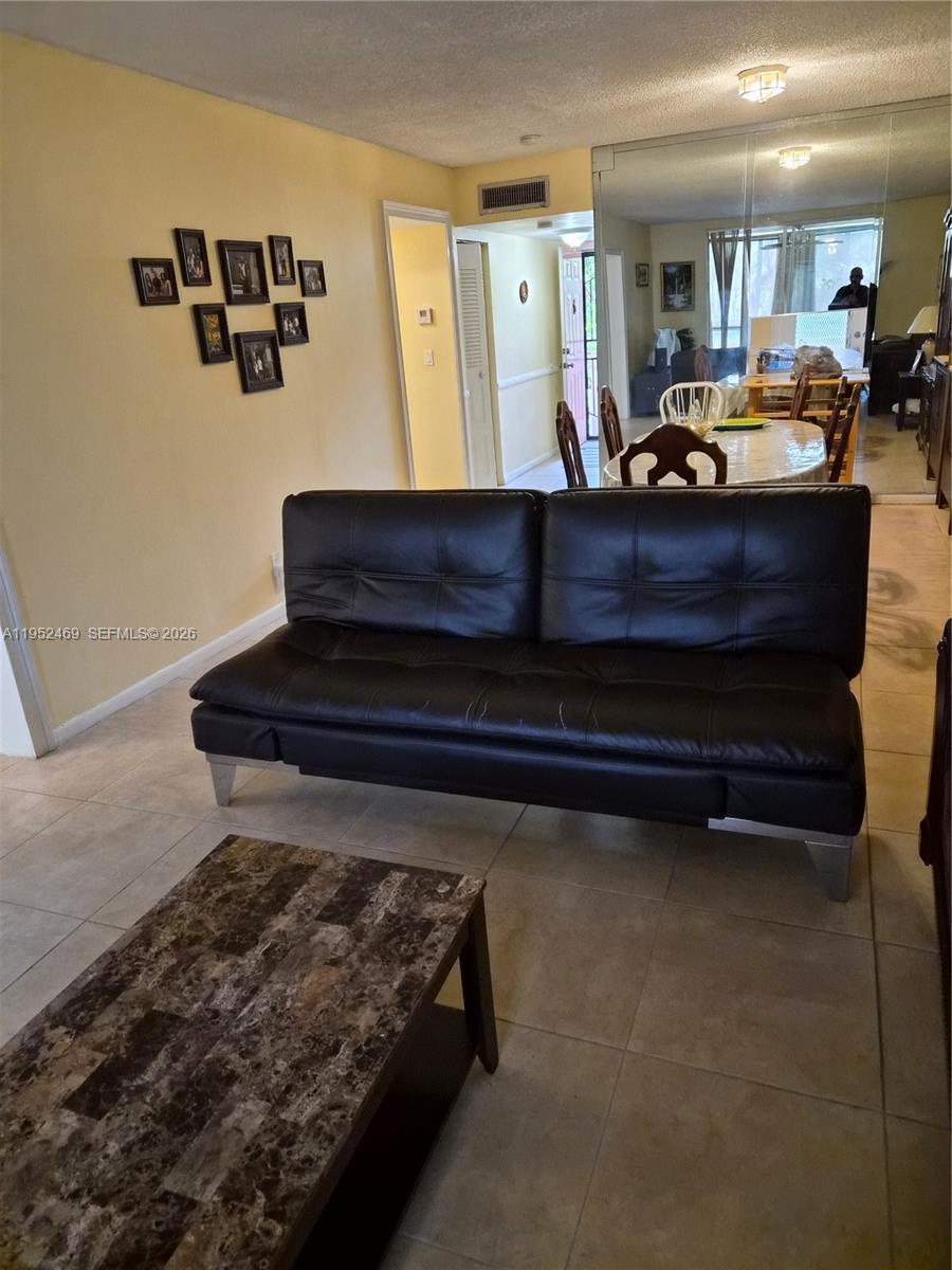 1101 Northwest 58th Terrace, Unit 202 Sunrise, FL 33313 - Photo 6 of 12 a living room with furniture flat screen tv and a table