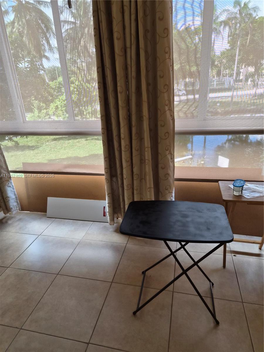 1101 Northwest 58th Terrace, Unit 202 Sunrise, FL 33313 - Photo 7 of 12 a table and chair in a room next to a window