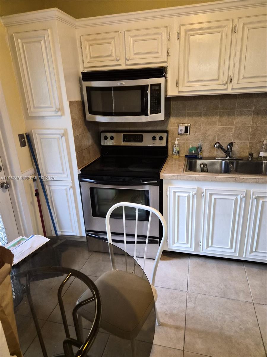 1101 Northwest 58th Terrace, Unit 202 Sunrise, FL 33313 - Photo 9 of 12 a kitchen with granite countertop a stove and a microwave
