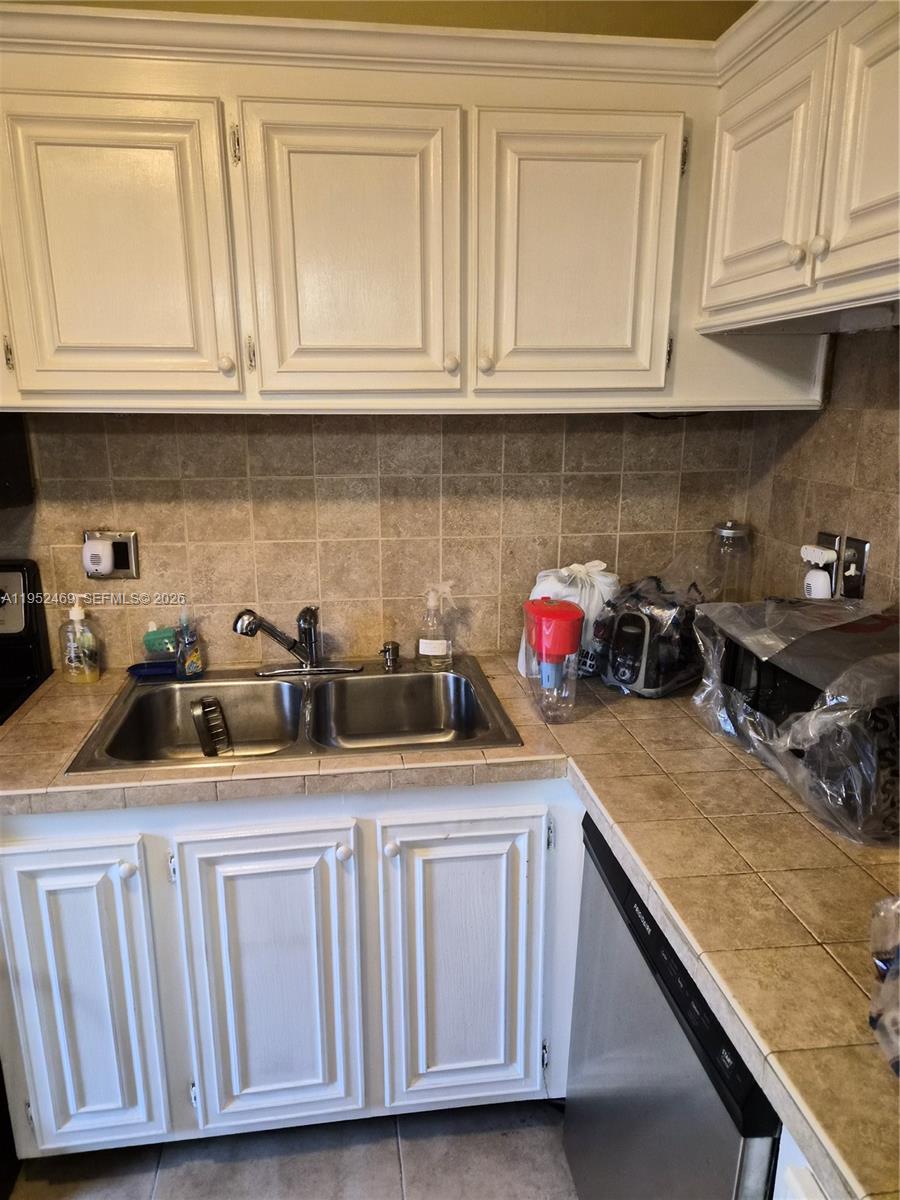 1101 Northwest 58th Terrace, Unit 202 Sunrise, FL 33313 - Photo 10 of 12 a kitchen with stainless steel appliances granite countertop a sink and cabinets