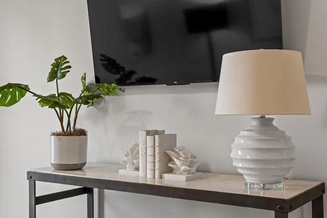 a bedroom with a bed a mirror on dresser and a chandelier