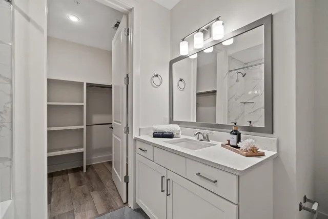 a bathroom with a granite countertop sink and a mirror