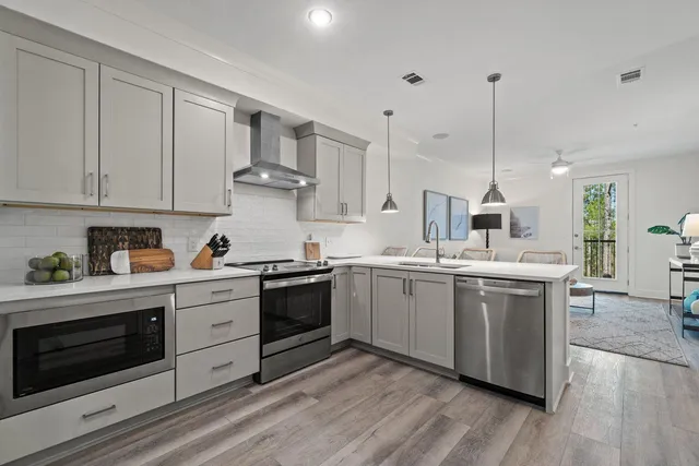 a kitchen with stainless steel appliances granite countertop a stove a sink and white cabinets
