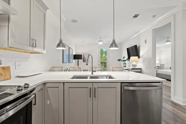 a kitchen with kitchen island granite countertop a sink stainless steel appliances and cabinets