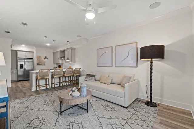 a living room with furniture and a dining table with kitchen view