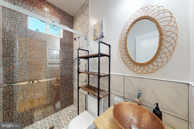 a bathroom with a granite countertop sink mirror and a bath tub