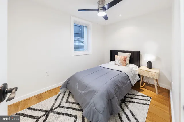a bedroom with a large bed and wooden floor
