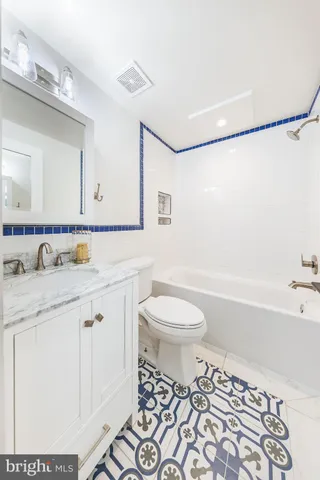 a bathroom with a sink toilet mirror vanity and shower