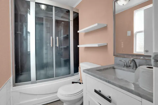 a bathroom with a granite countertop sink toilet and shower
