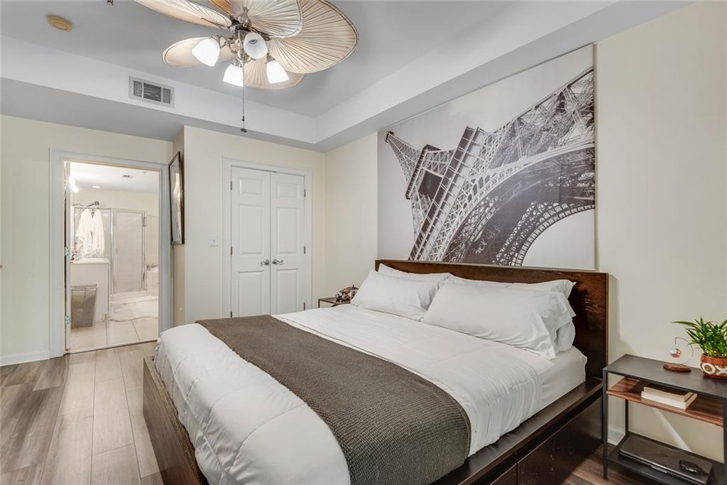 3275 Lenox Road Northeast, Unit 108 Atlanta, GA 30324 - Photo 8 of 22 a bedroom with a large bed and a chandelier