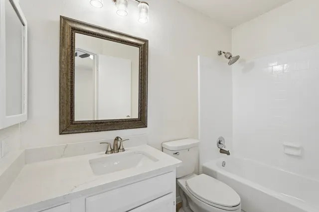 a bathroom with a sink toilet vanity and shower