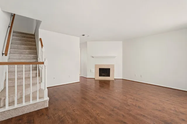 an empty room with wooden floor and fireplace