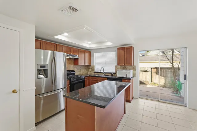 a kitchen with stainless steel appliances granite countertop a refrigerator a stove a sink and a refrigerator
